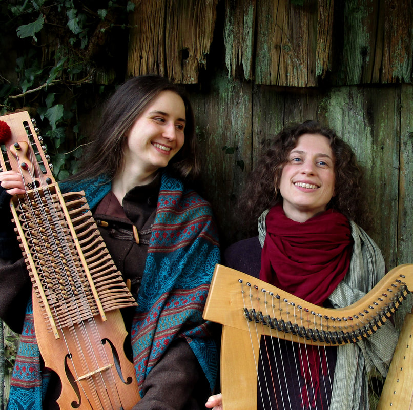 Harpavei in front of an ivy-covered wall, Sara Buffler with her harp and Emelie Waldken with her nyckelharpa.